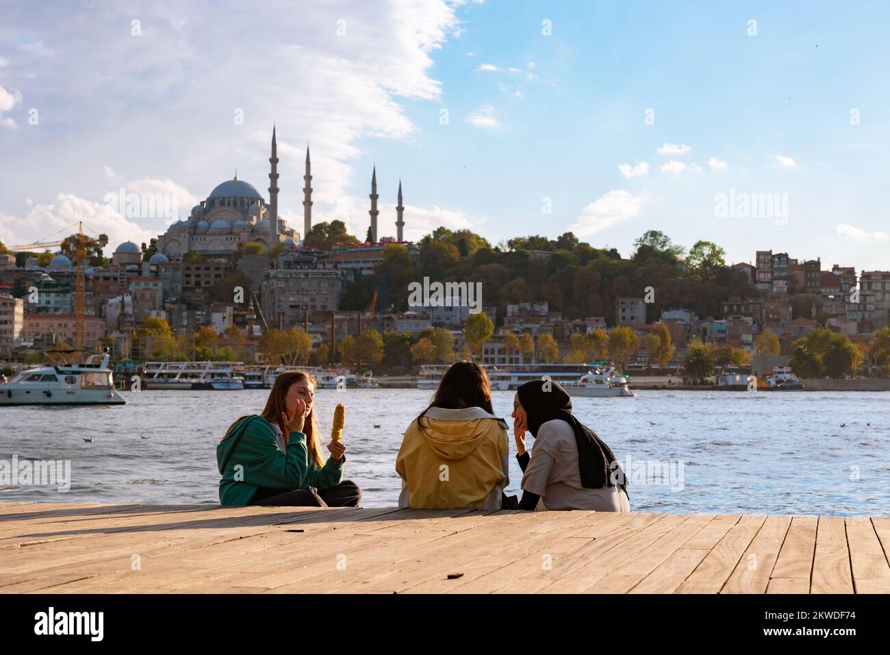 Turkish youth. Hijabi and non-hijabi friends near the Golden Horn in Istanbul. Religios and secular young Turks. Istanbul Turkiye - 10.4.2022 Stock Photo