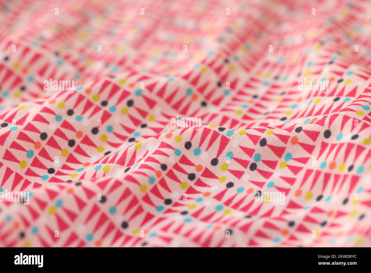 Wavy multicolored fabric with geometric ornament as background. Stock Photo