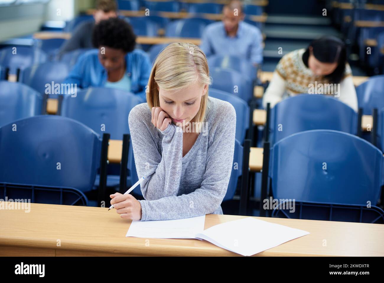 Im a bit stumped on this question. an attractive college student studying in a lecture hall. Stock Photo