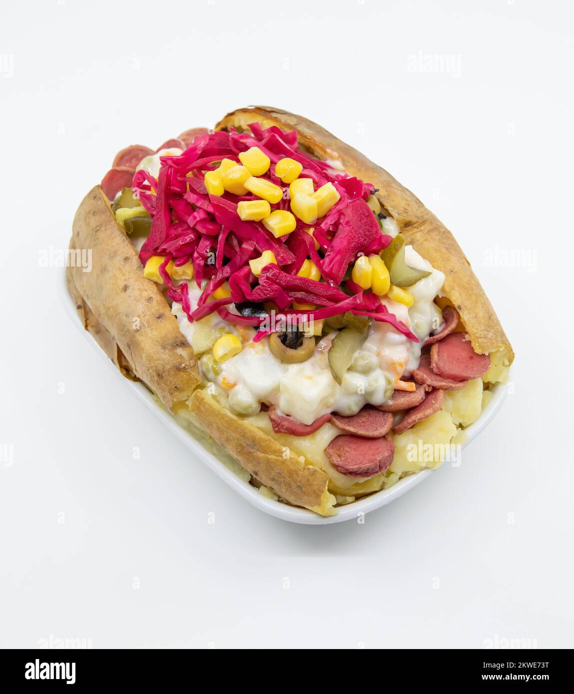 Kumpir, Turkish baked potato with cheese, corn, sausage, ketchup, mayonnaise and olives. This kumpir is traditional Turkish food isolated on white bac Stock Photo