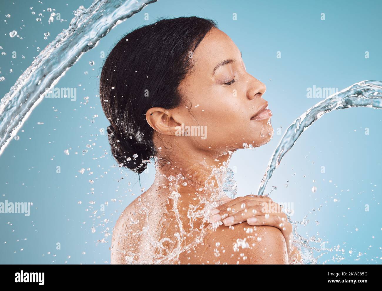 Water, splash and clean beauty with black woman profile and skincare, wellness with hydration and hygiene in blue background mockup. Skin, face and Stock Photo
