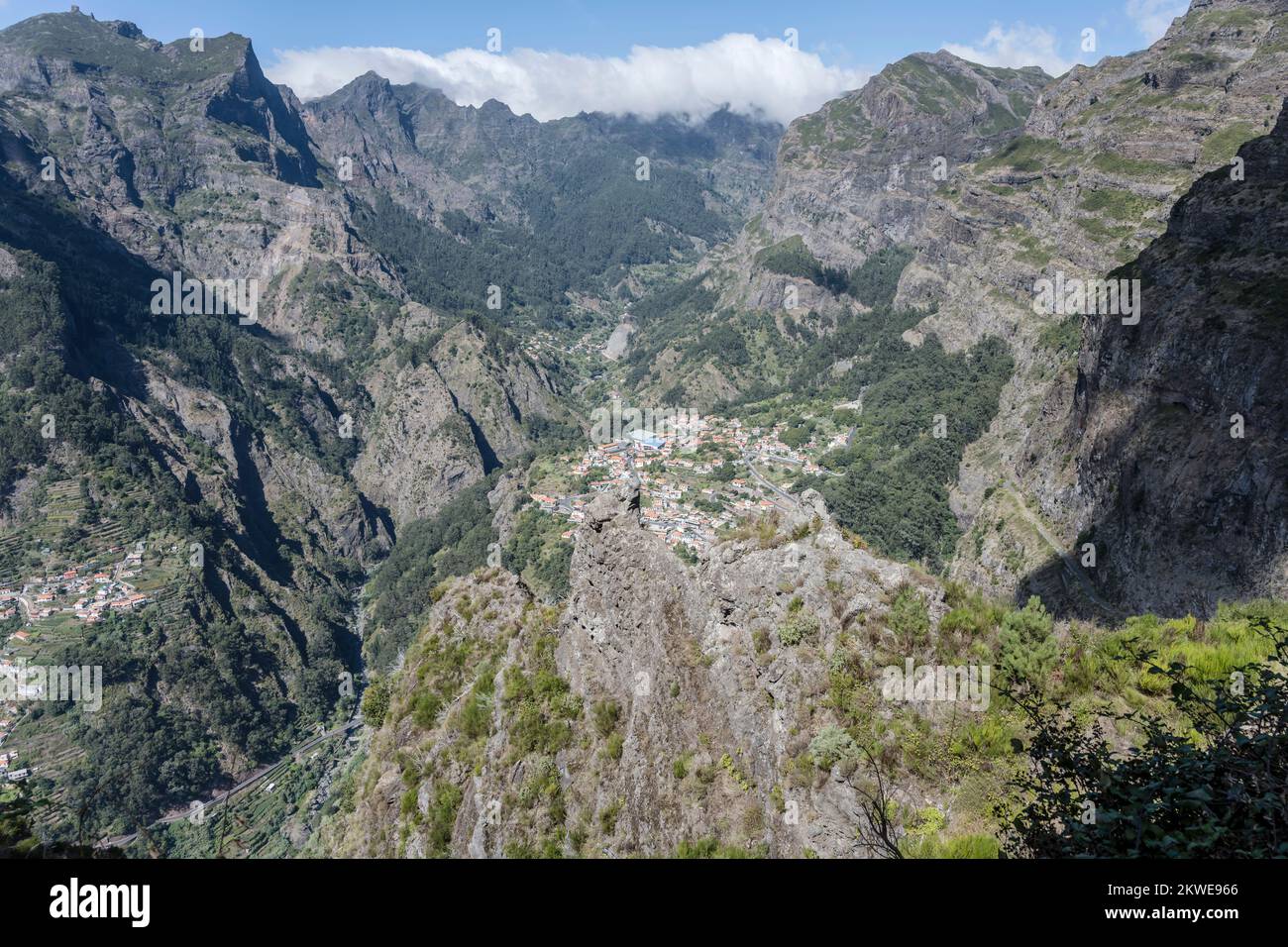 aerial landscape with steep volcanic slopes of green valley and mountain village of Curral des Freiras at  inland of Madeira island, shot in bright fa Stock Photo