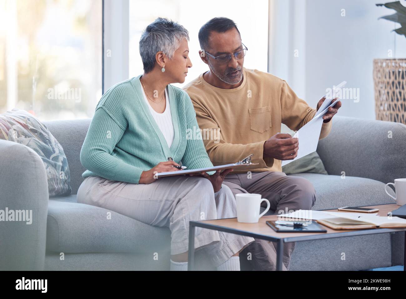 Finance, documents and senior couple on sofa with bills, paperwork and