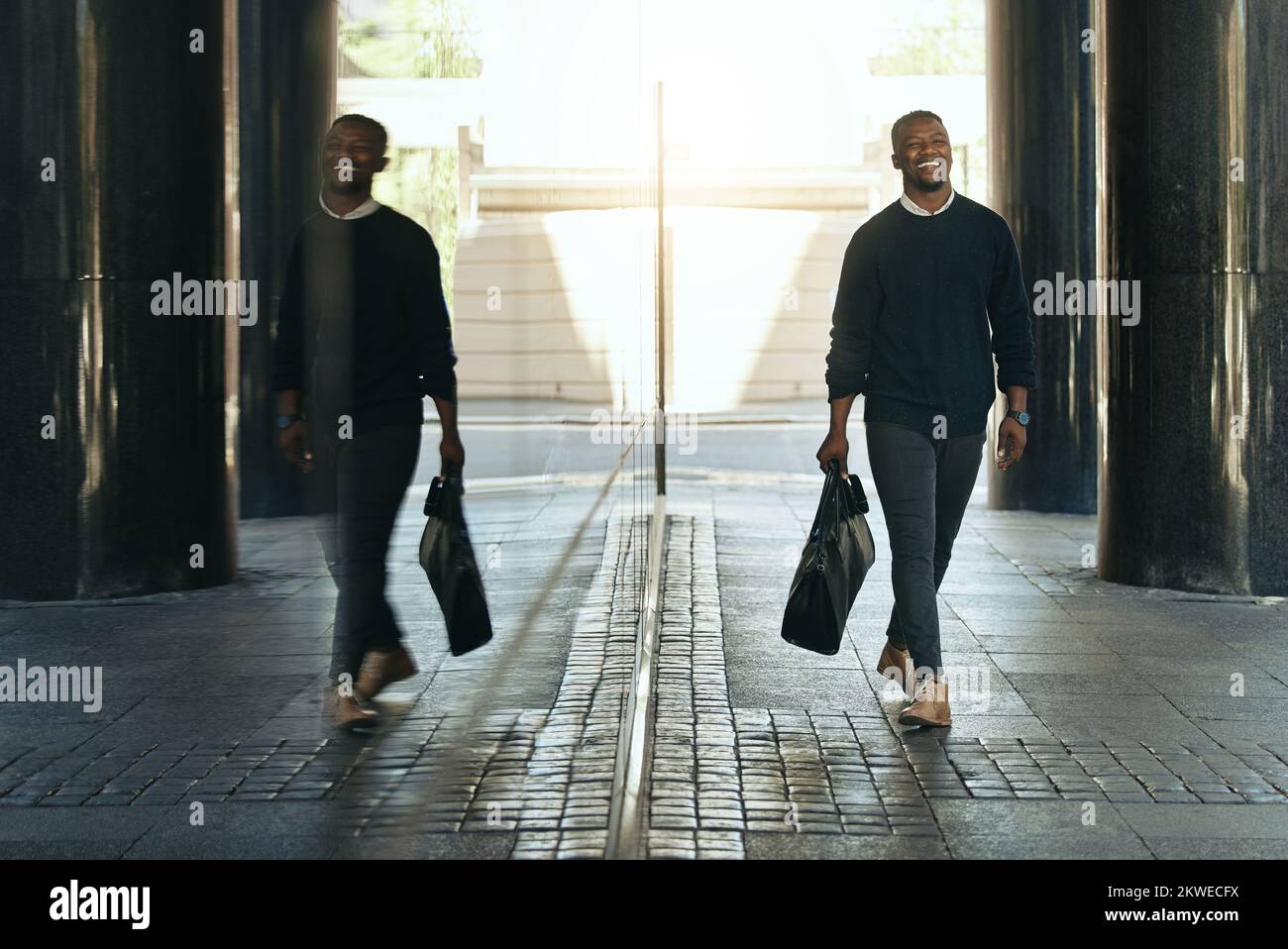 Happy, travel and business man walking to work at corporate company in the city with dark aesthetic background and reflection. Smile of a black man or Stock Photo