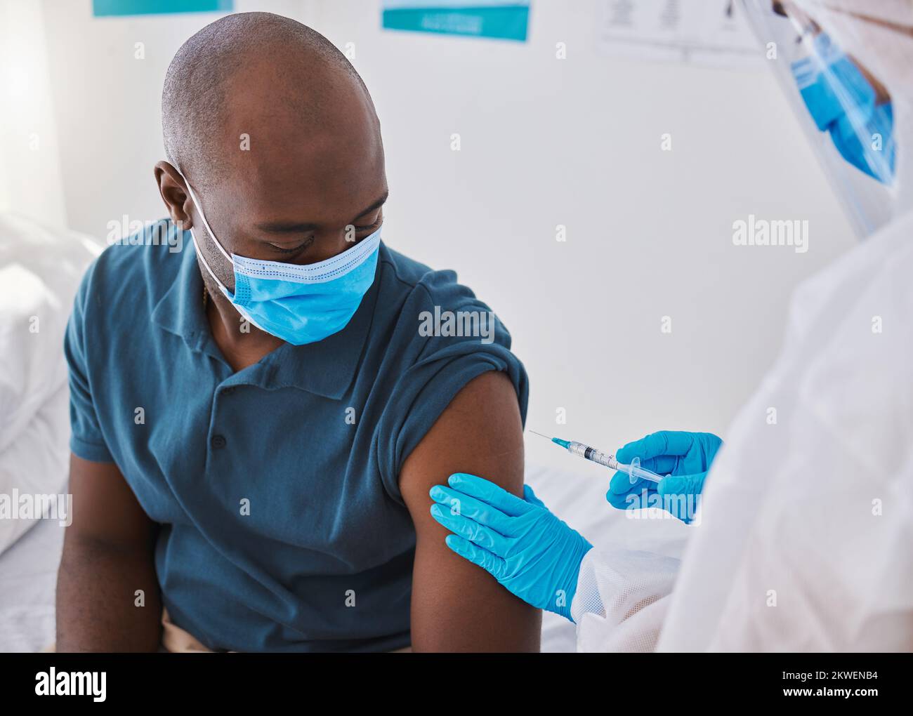 Vaccine, injection and virus cure for covid, disease and pandemic illness from doctor, healthcare or medical professional. Male patient with mask Stock Photo