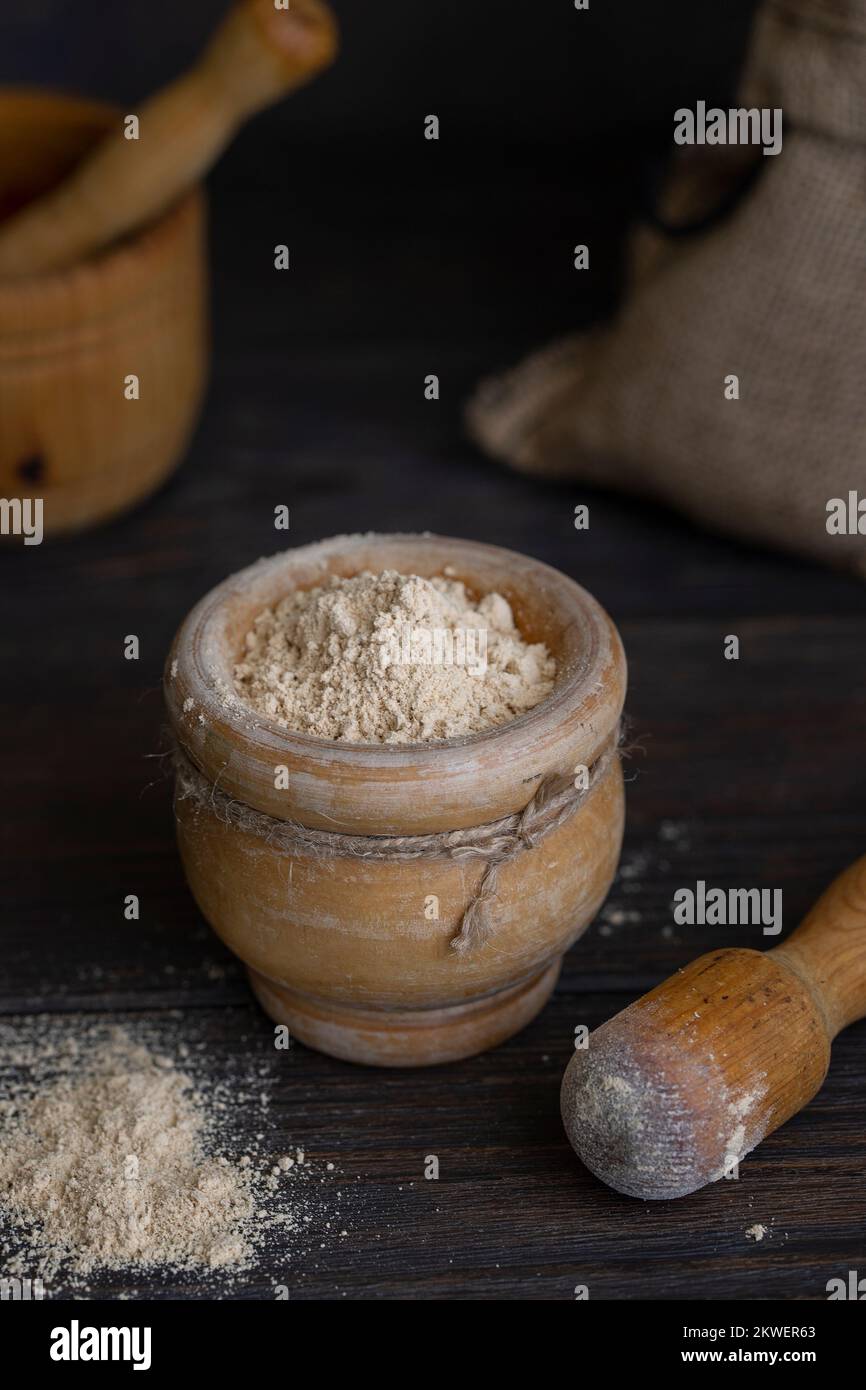 Gofio, Canarian flour  in wood mortar  on wooden background . This is important ingredient of many dish of Canary Islands Cuisine. Stock Photo