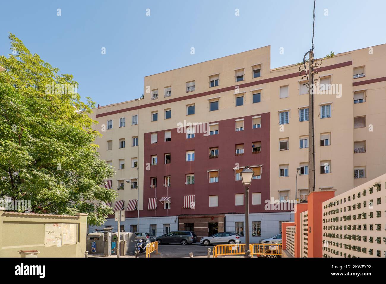 Facades of two-tone buildings with square windows and striped fabric awnings Stock Photo