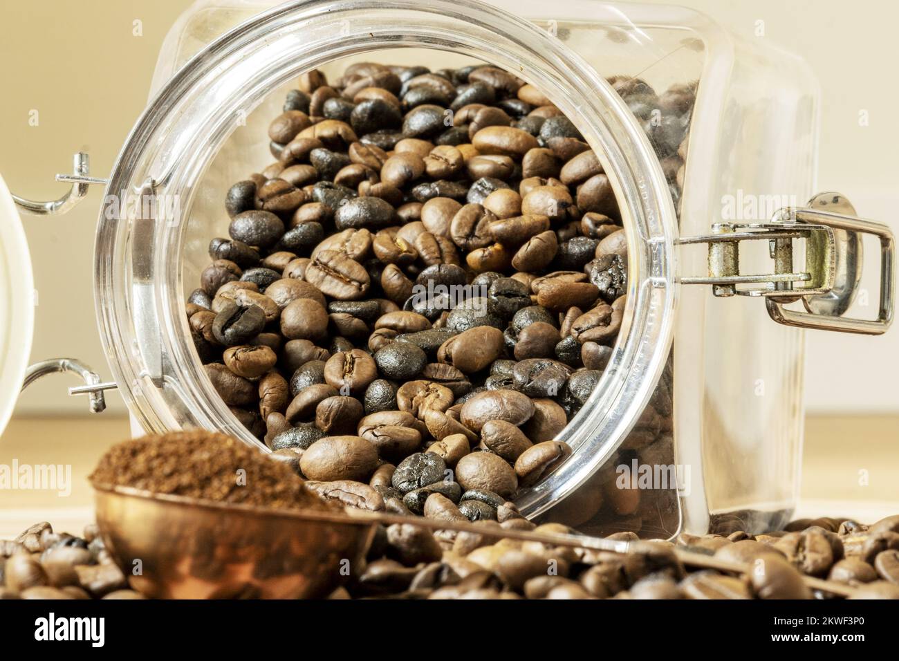 Overturned coffee beans from a tin and a copper meter with ground