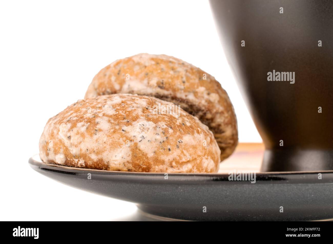 Two sweet delicious gingerbread cookies with black ceramic cup on ceramic plate, macro isolated on white background. Stock Photo