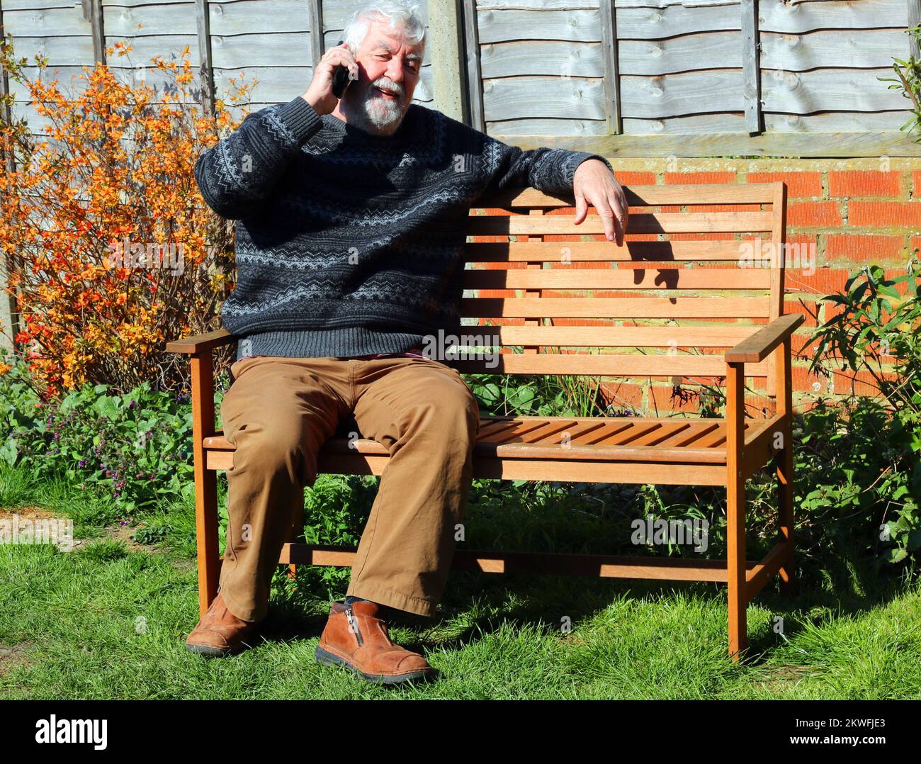 elderly or senior man sitting outside and using his mobile phone Stock ...