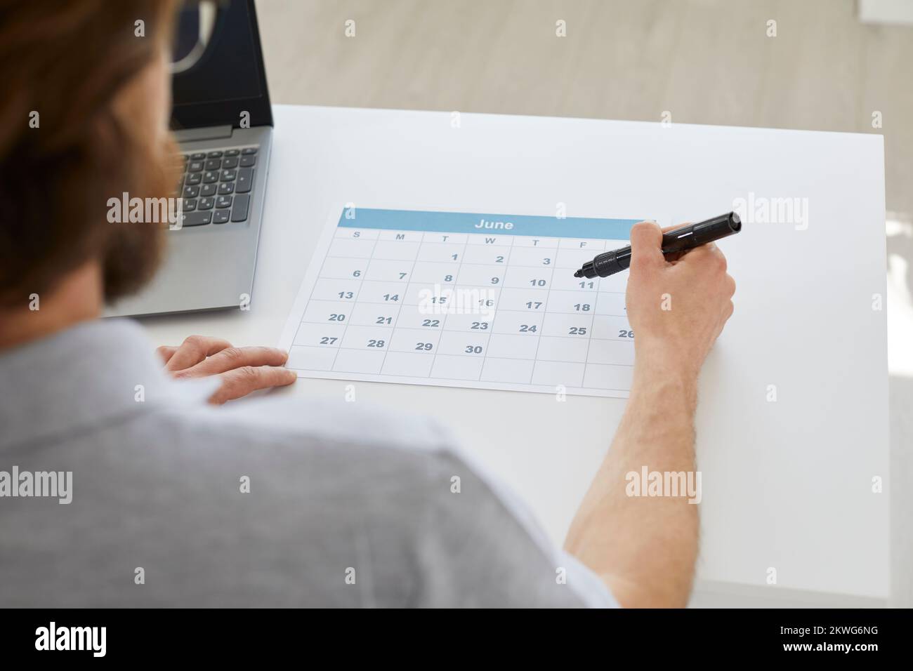 Businessman sitting at his desk and using a calendar to organize his business schedule Stock Photo