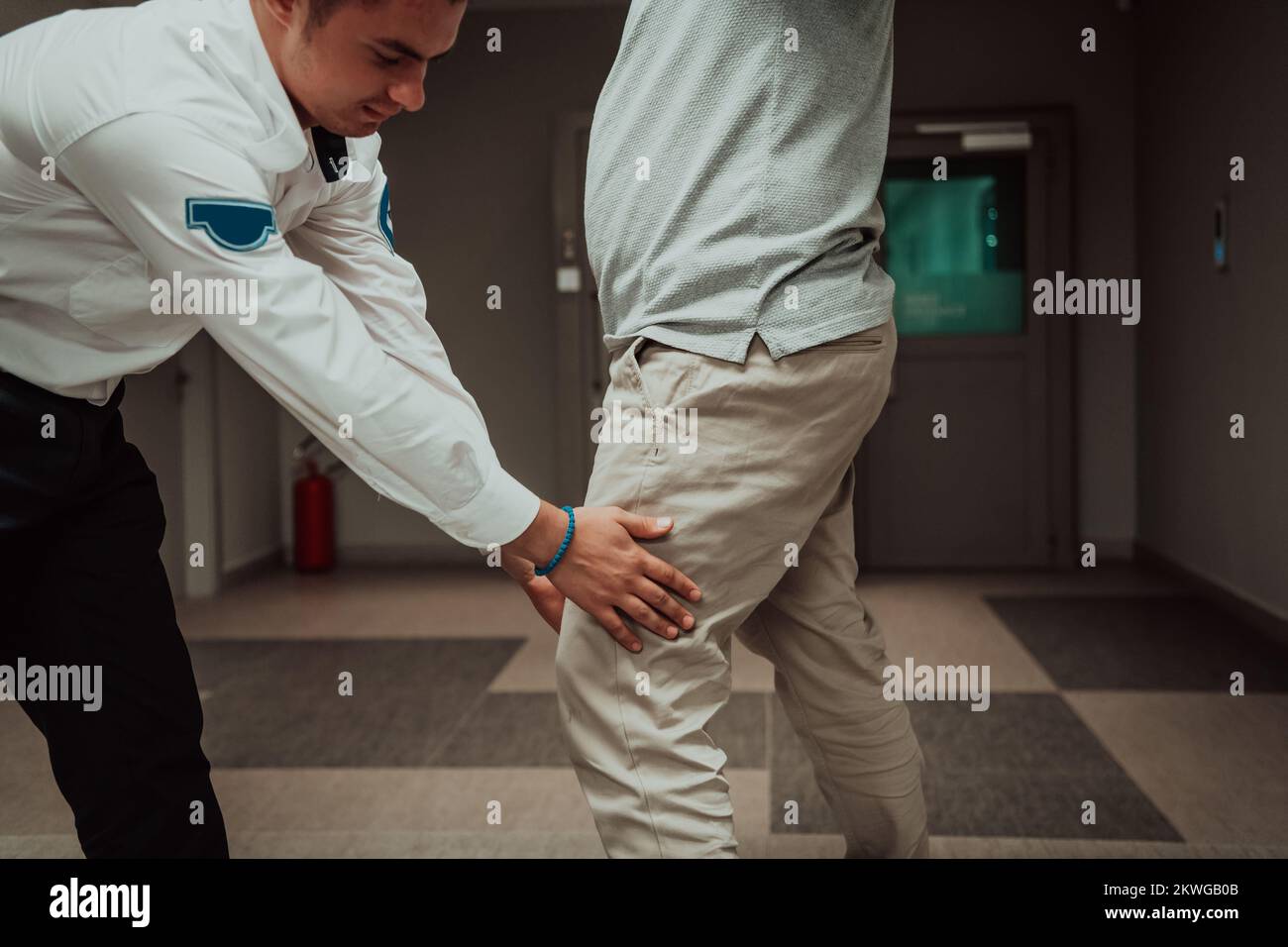 Security guard making body searching procedure on man for finding