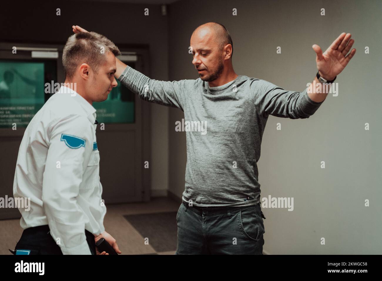 Security guard making body searching procedure on man for finding