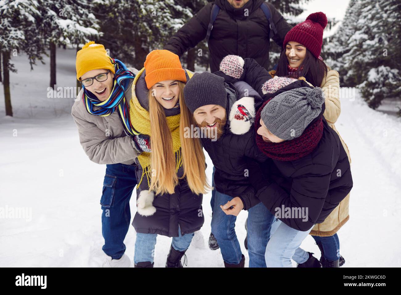 Smiling friends have fun enjoy walk in snowy forest Stock Photo