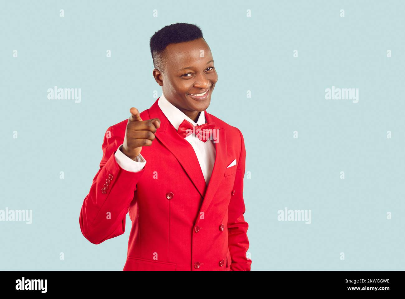 Friendly young stylish African American man points finger at you inviting you to party. Stock Photo