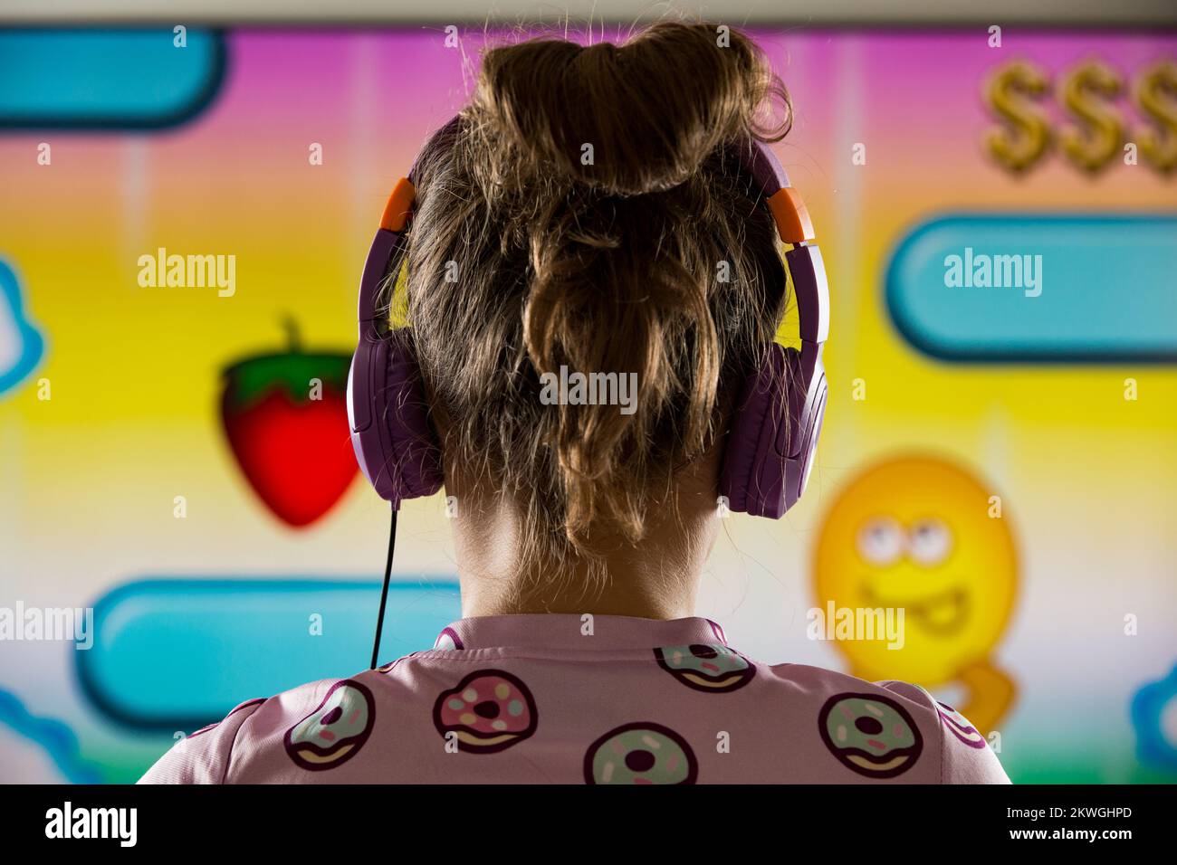 A child or teenager is playing computer video games on a large screen. Online video game technology and teen gaming addiction Stock Photo