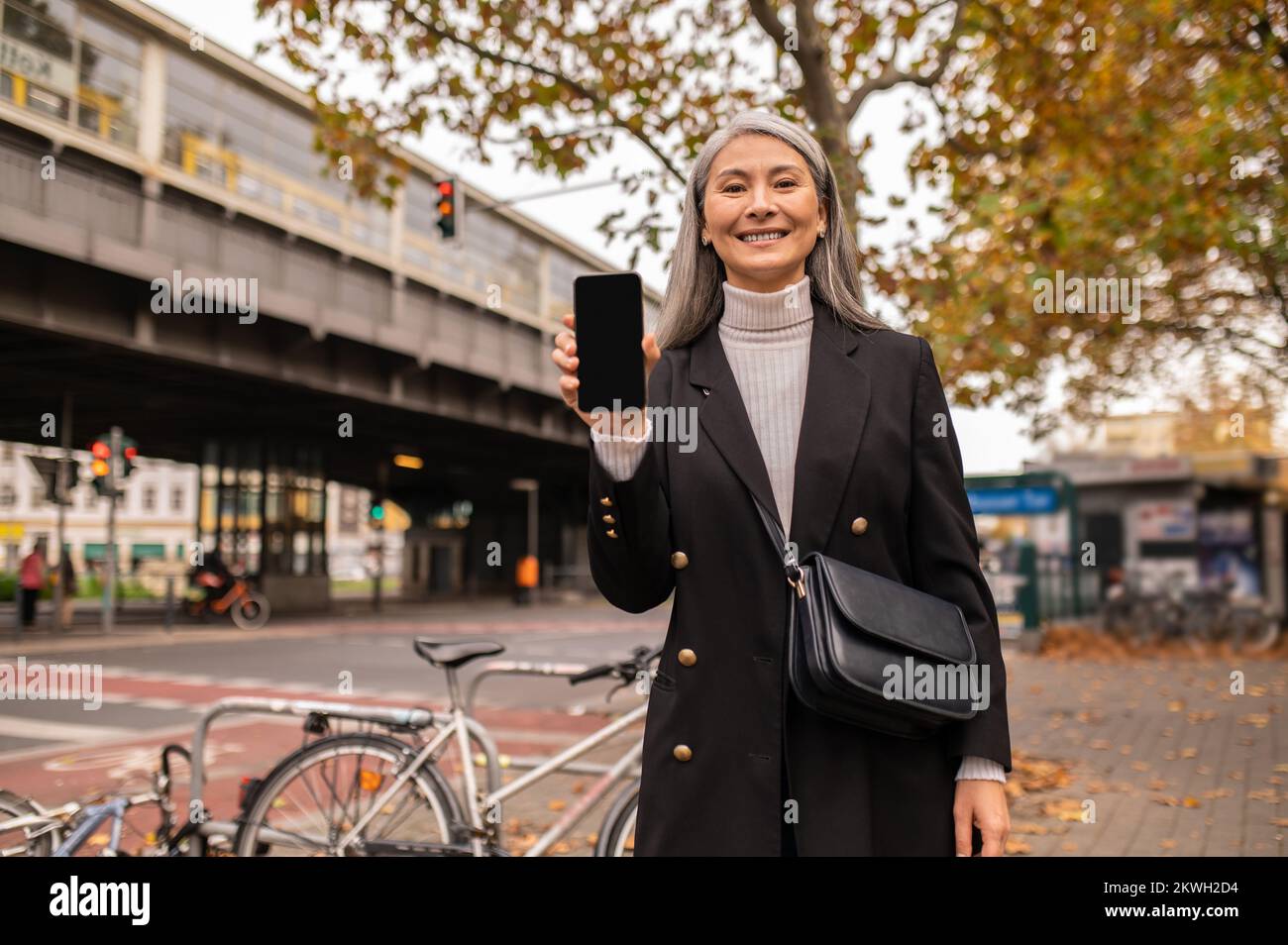 Woman with a smartphone near the train station Stock Photo