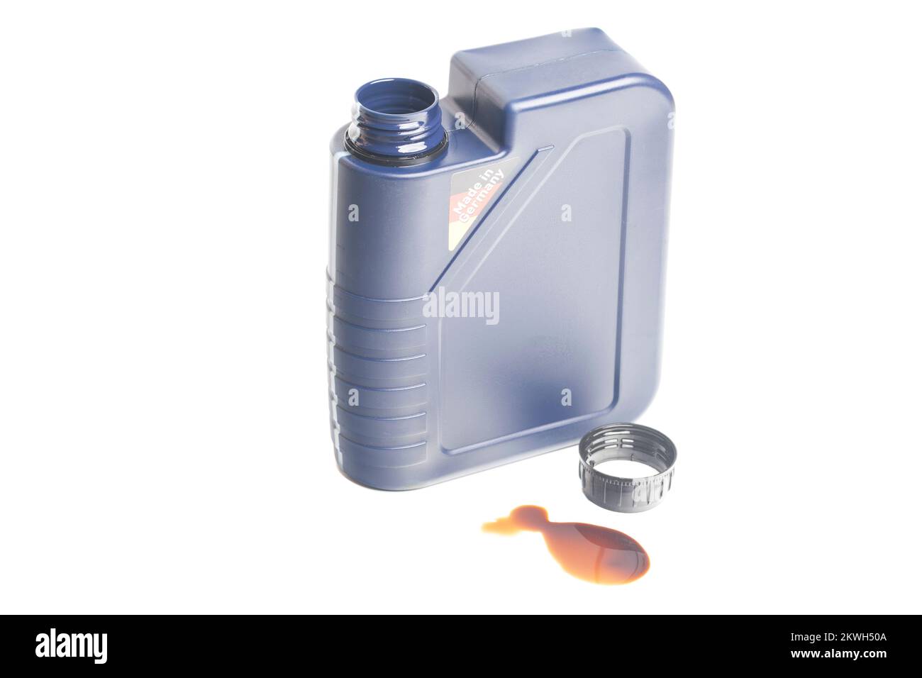 open engine oil bottle with a puddle of engine oil isolated on white