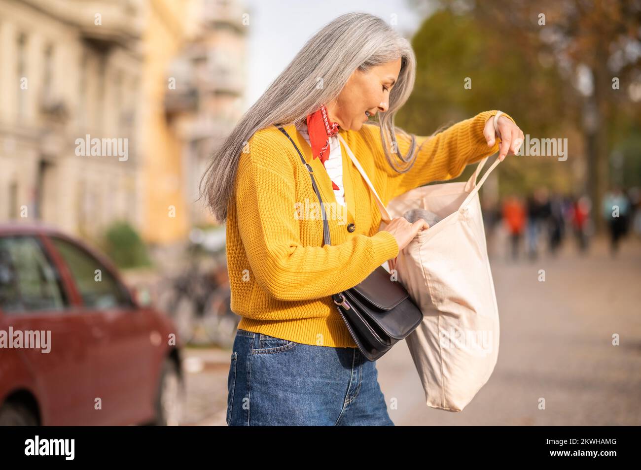Woman with a papaer bag after shopping in a city street Stock Photo