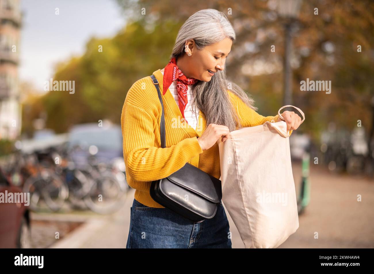 Woman with a papaer bag after shopping in a city street Stock Photo
