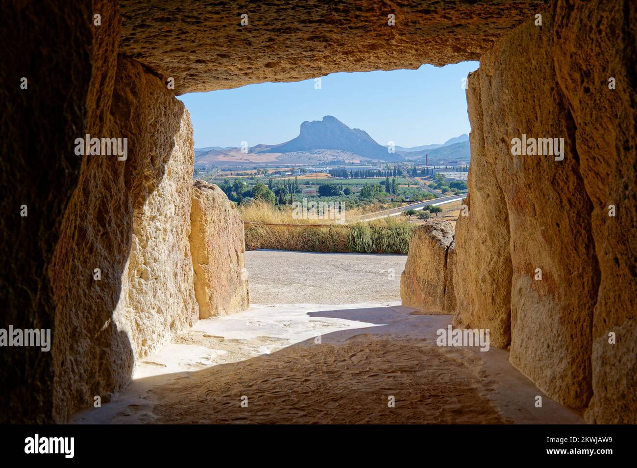 Interior of the megalithic monument Dolmens in Antequera with the natural monument The Lovers' Rock in the background. Touristic travel to Spain. Stock Photo