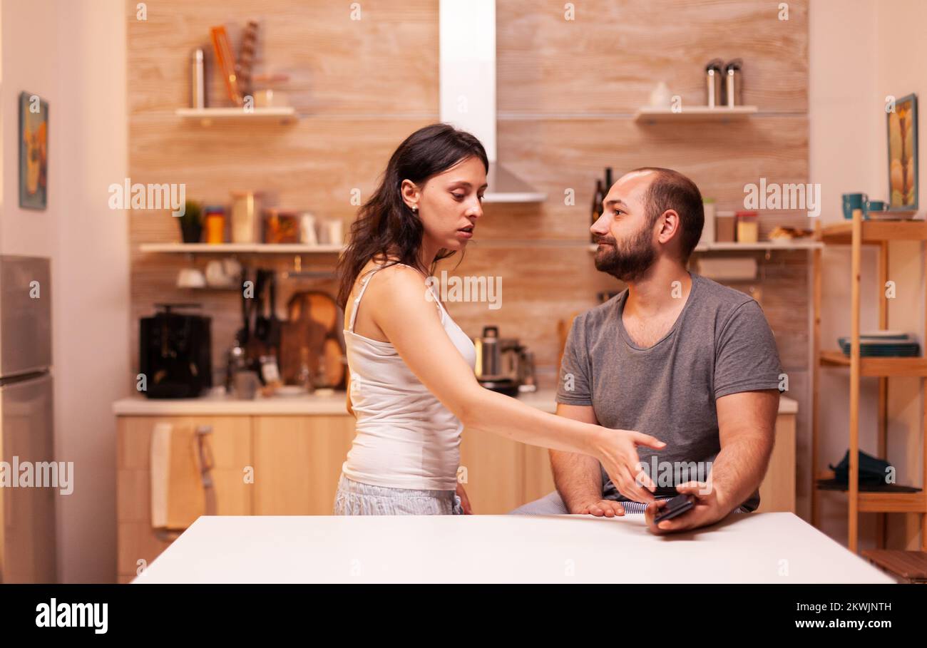 Desperate jelous wife asking husband phone to check messages. Heated angry frustrated offended irritated accusing her man of infidelity. Stock Photo