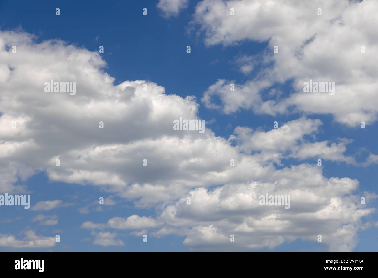summer blue sky of various shades and white fluffy light cumulus clouds floating in height Stock Photo