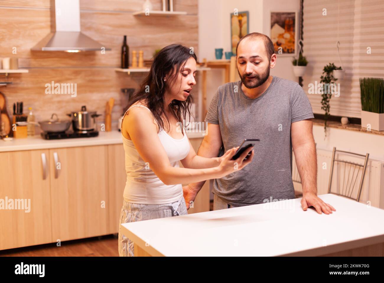 Wife screaming at unfaithful husband in the kitchen. Jealous woman