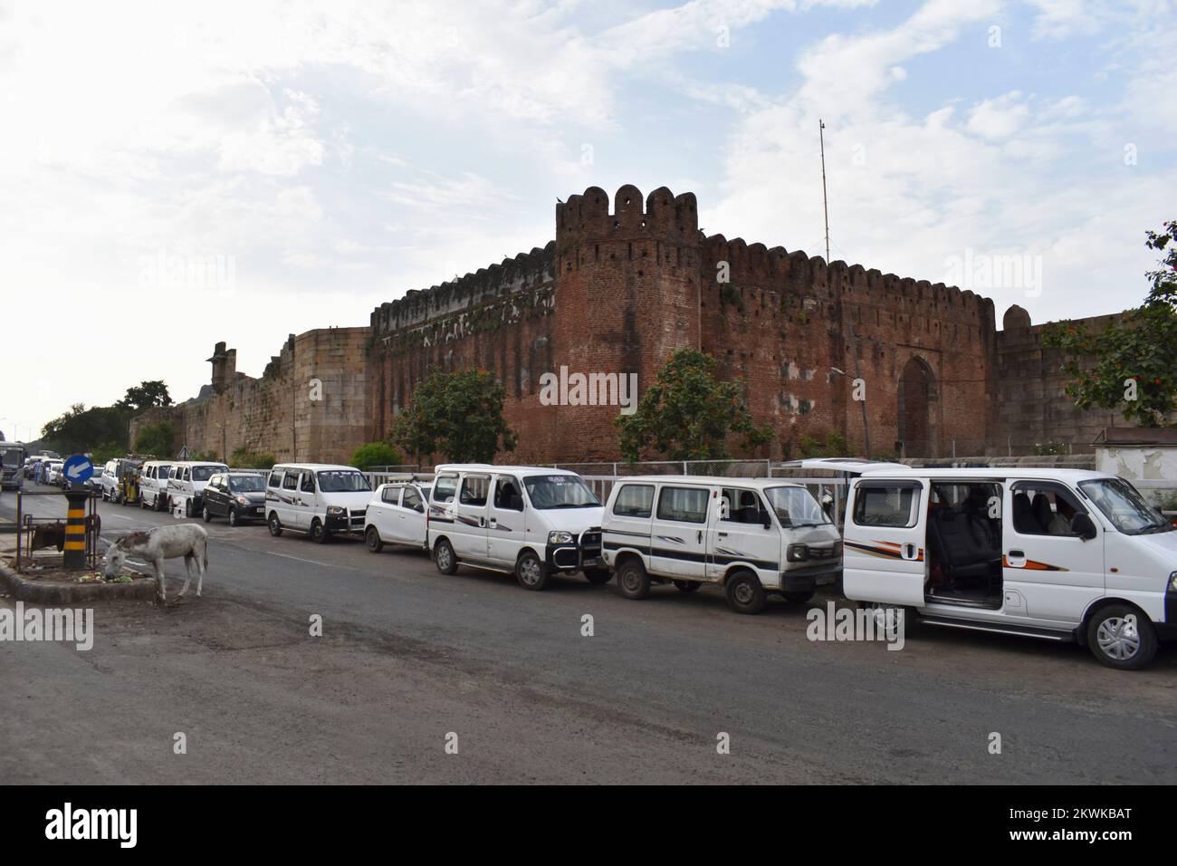 INDIA, GUJRAT, CHAMPANER, October 2022, Long line of tourist cars and vans parked in a line at South Bhadra Gate and veiw of Champaner Fort Wall, A UN Stock Photo