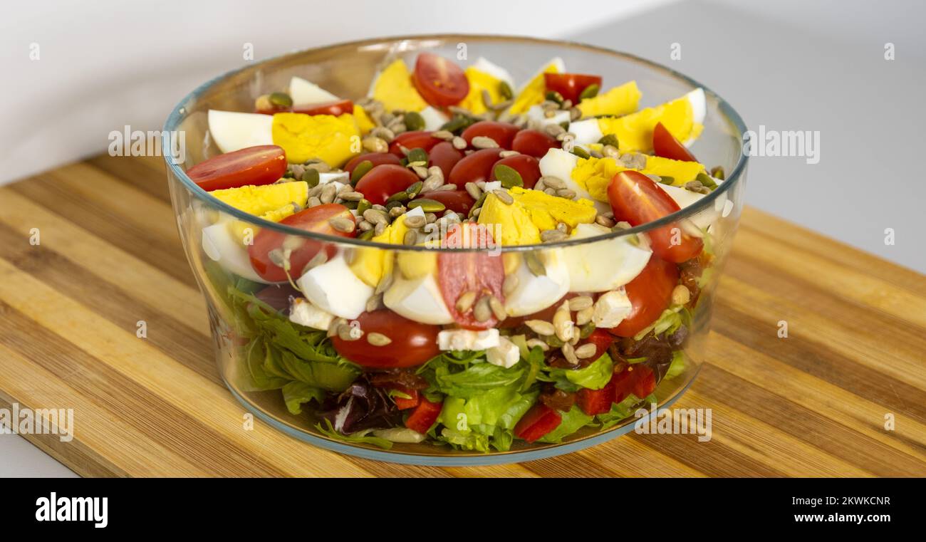 Salad with quartered egg, tomato, lettuce, and grains in a bowl on the