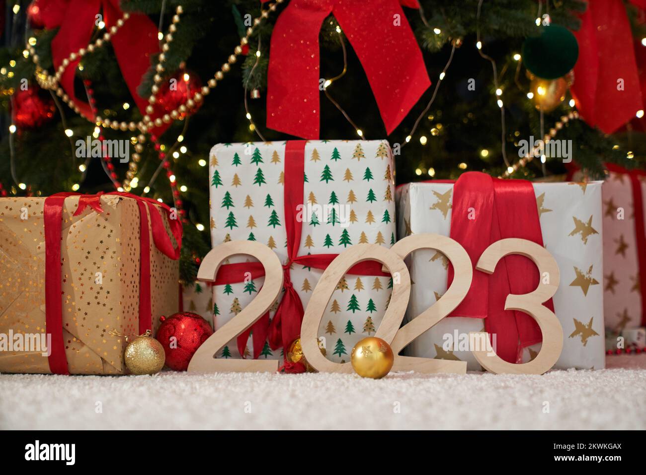 Close up of christmas tree decorated with red bows and golden balls standing in studio. People celebrating new year, waiting, expecting. Concept of new year and celebration. Stock Photo