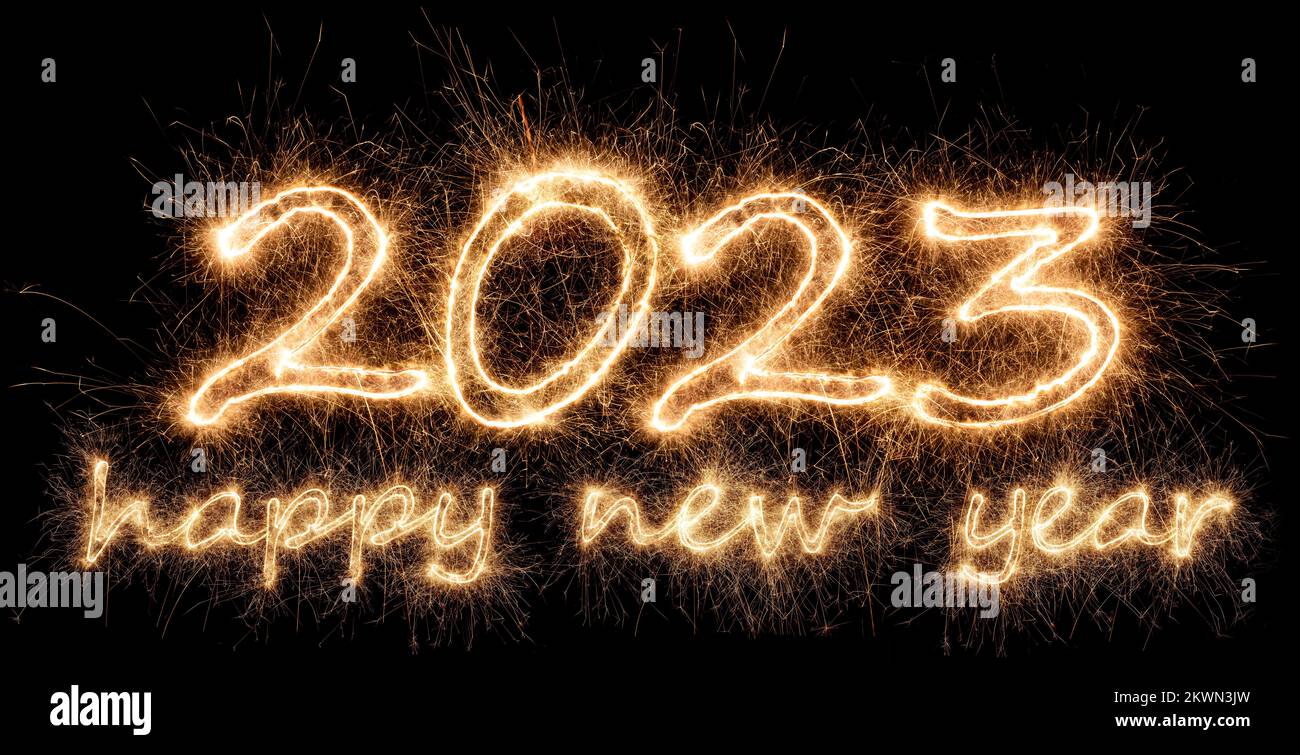 2023 sparkler golden number with happy new year eve greetings bright gold fireworks display on black. dark celebration change of the year concept back Stock Photo