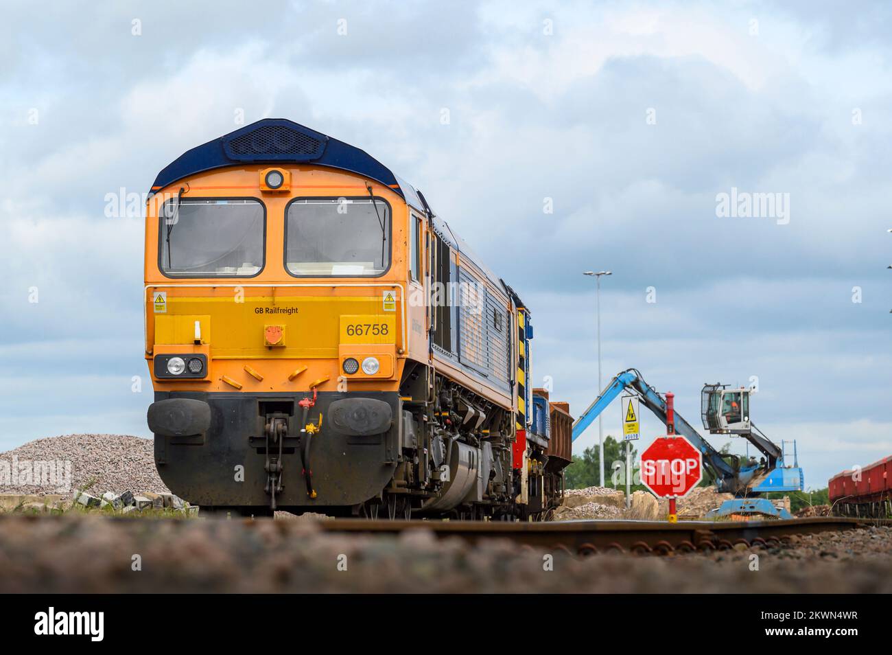 Class 66 diesel locomotive in GB Railfreight livery hauling ballast wagons on the Uk railway, England. Stock Photo