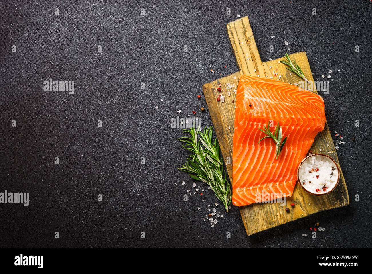 Raw salmon, fresh fish fillet at black background Stock Photo - Alamy