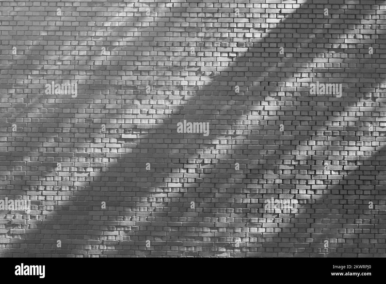 Diagonal shadows and lines falling on a typical common brick wall Ina