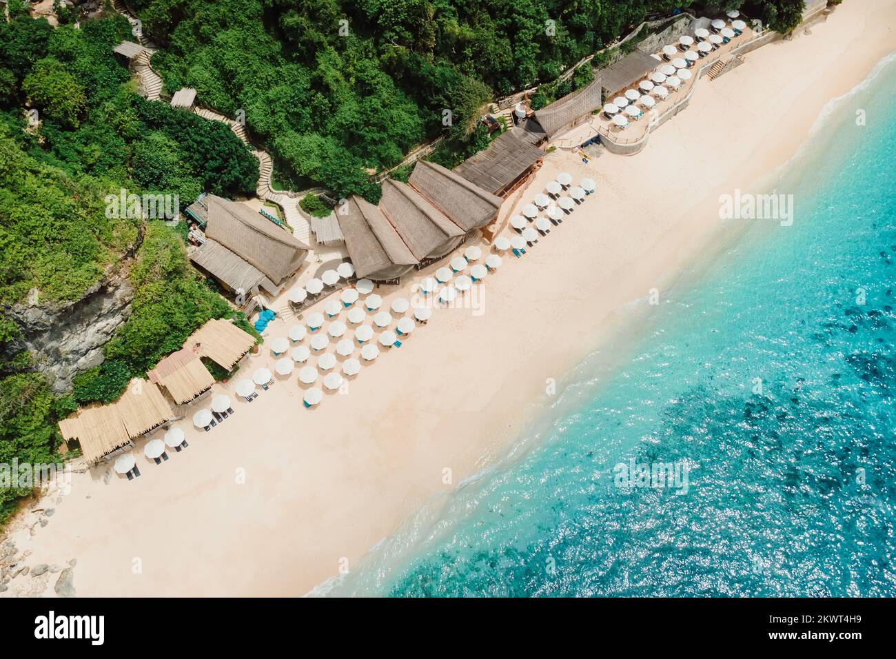 Aerial view of blue ocean and luxury beach with umbrellas in Bali Stock Photo