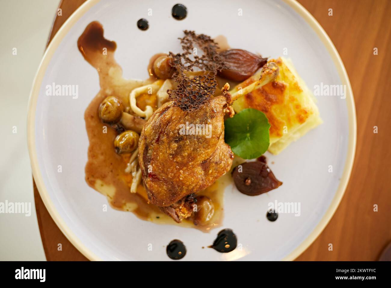 Roasted duck leg in prune sauce with potatoes Stock Photo