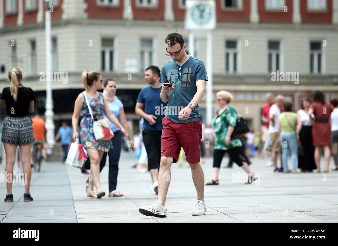 25.07.2016., Croatia, Zagreb - Lifestyle in the city center. More and more people spend time looking at their cell phones. So you can often encounter a society that do not even talk to each other but everyone looks at their gadget, especially lately when in our region can be downloaded game Pokemon Go whose goal is looking into the application to seek and collect Pokémon around city.  Stock Photo