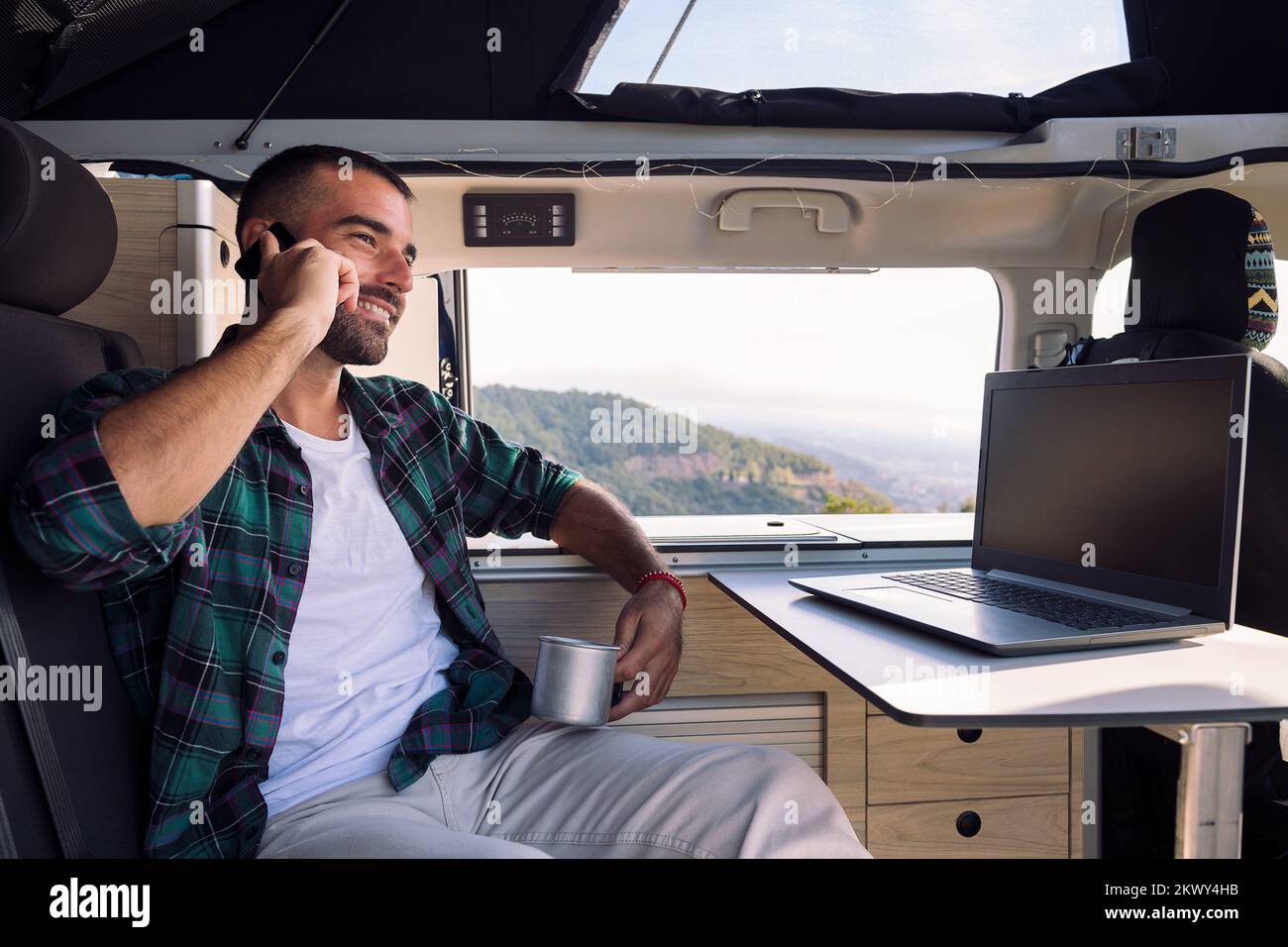 man inside his camper van talking on mobile phone Stock Photo