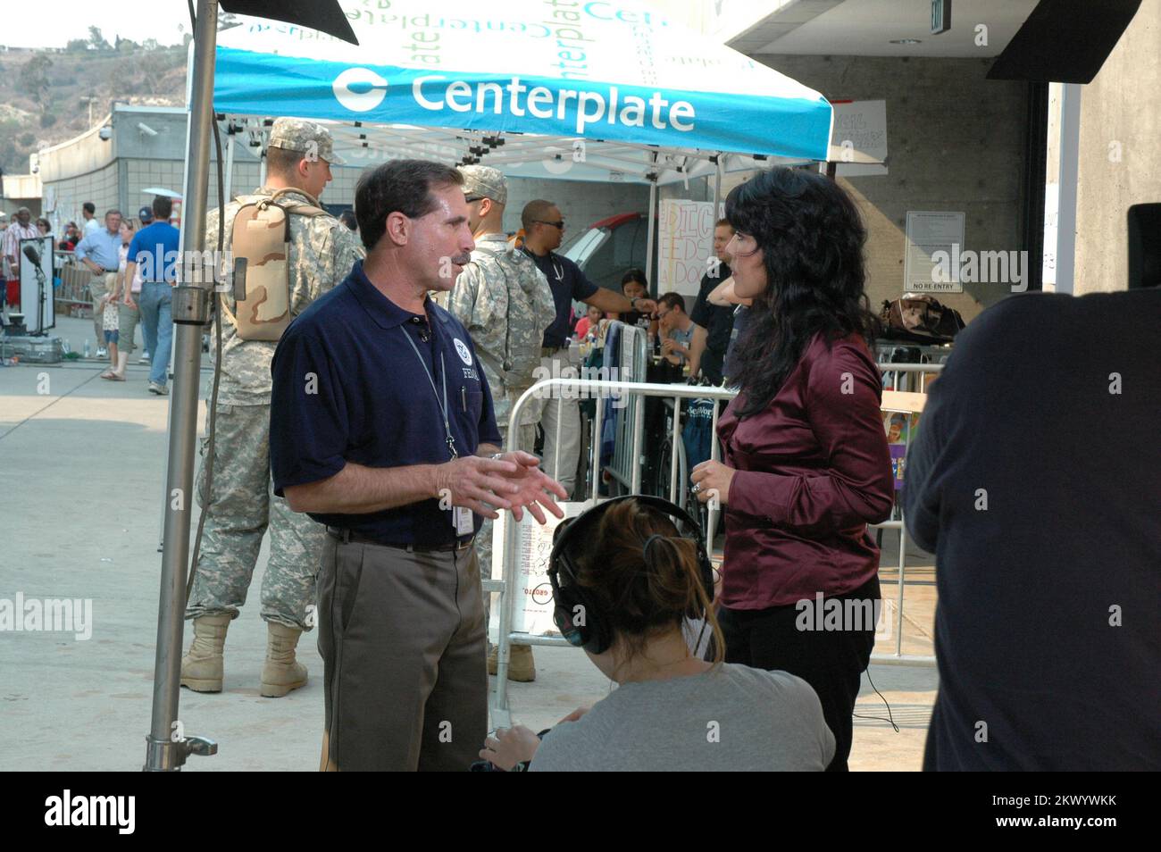 Wildfires,  San Diego, California, October 24, 2007   Lee Rosenberg, Task Force Leader at Qualcomm Stadium, explains FEMA programs to CNN reporter Thelma Gutierrez. The Southern California wildfires, concentrated in San Diego County and the Los Angeles County mountains, generated a major disaster declaration by the President today. Michael Raphael/FEMA.. Photographs Relating to Disasters and Emergency Management Programs, Activities, and Officials Stock Photo