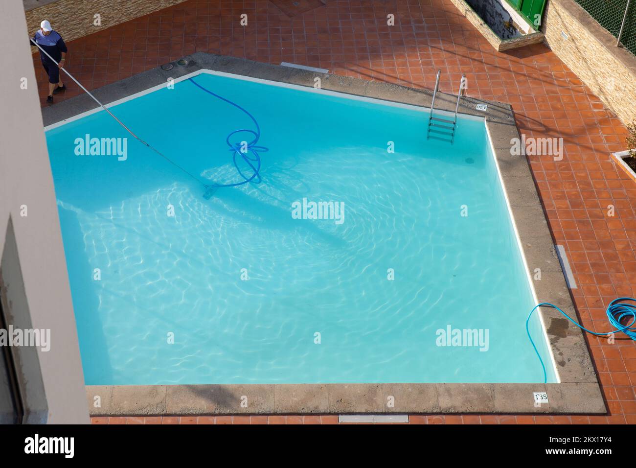 Man cleaning the swimming pool with vacuum equipment. swimming pool