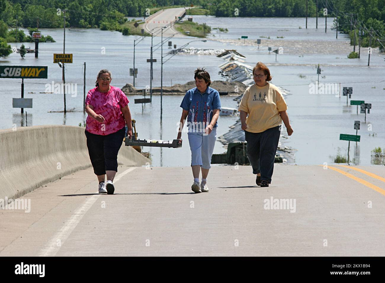 Severe Storms, Tornadoes, and Flooding,  Columbus Junction, IA, June 17, 2008   Local residents Janice Pugh, Frieda Sojka, and Cathy Crawford made the long walk up the highway 92 ramp after delivering homemade lunches to the Iowa National Guardsmen manning the roadblock to the flooded road. The ladies have earned a reputation as the best cooks in Louisa County.. Photographs Relating to Disasters and Emergency Management Programs, Activities, and Officials Stock Photo