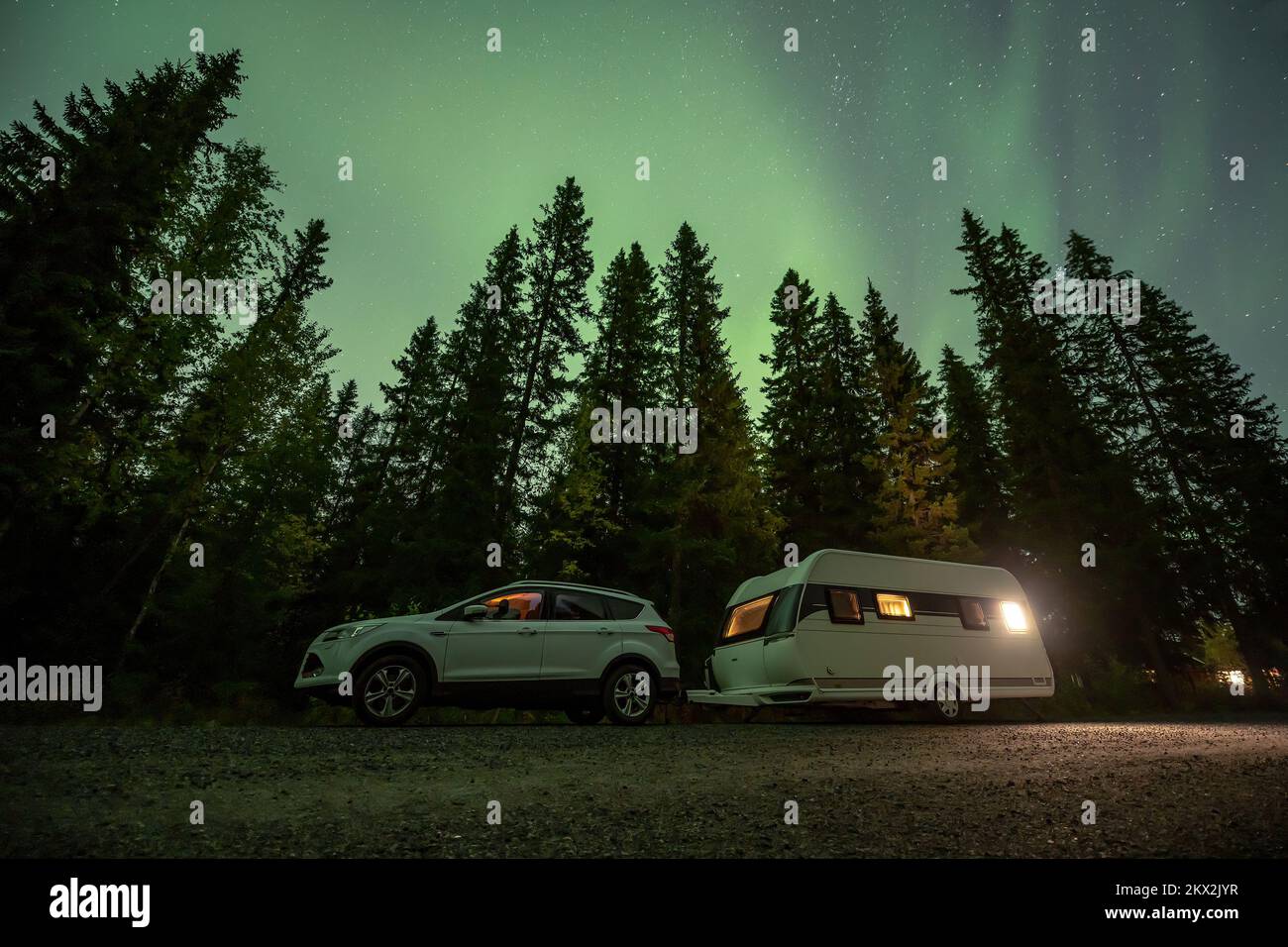 Aurora shining over Camping Caravan in Swedish forest landscape