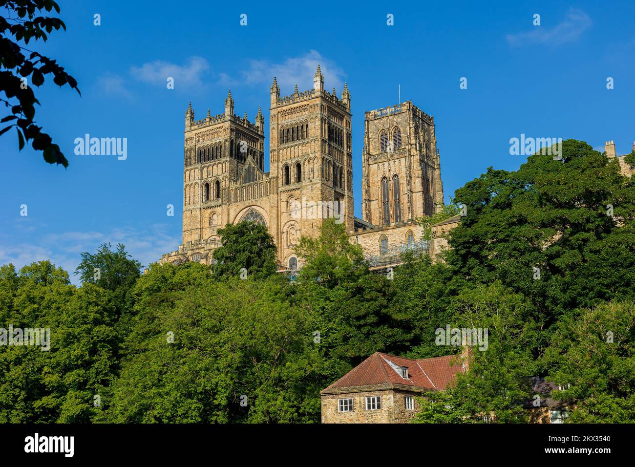 Durham England: 2022-06-07: Durham Cathedral exterior during sunny summer day. View from river wear with lush green trees Stock Photo