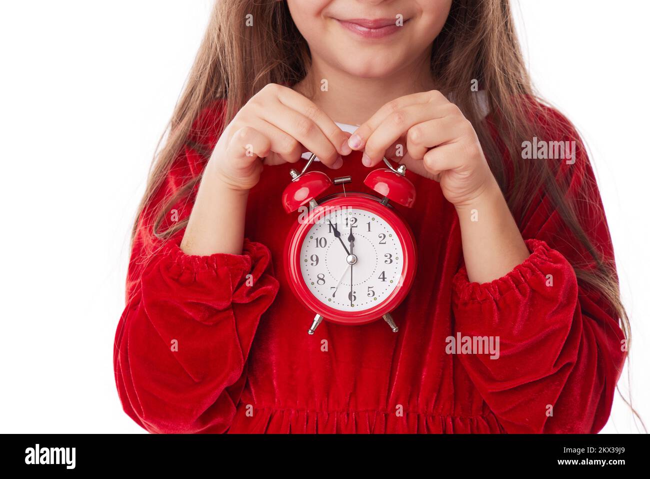 Christmas woman with red alarm clock, smiling girl in red Santa claus dress posing on white background Stock Photo