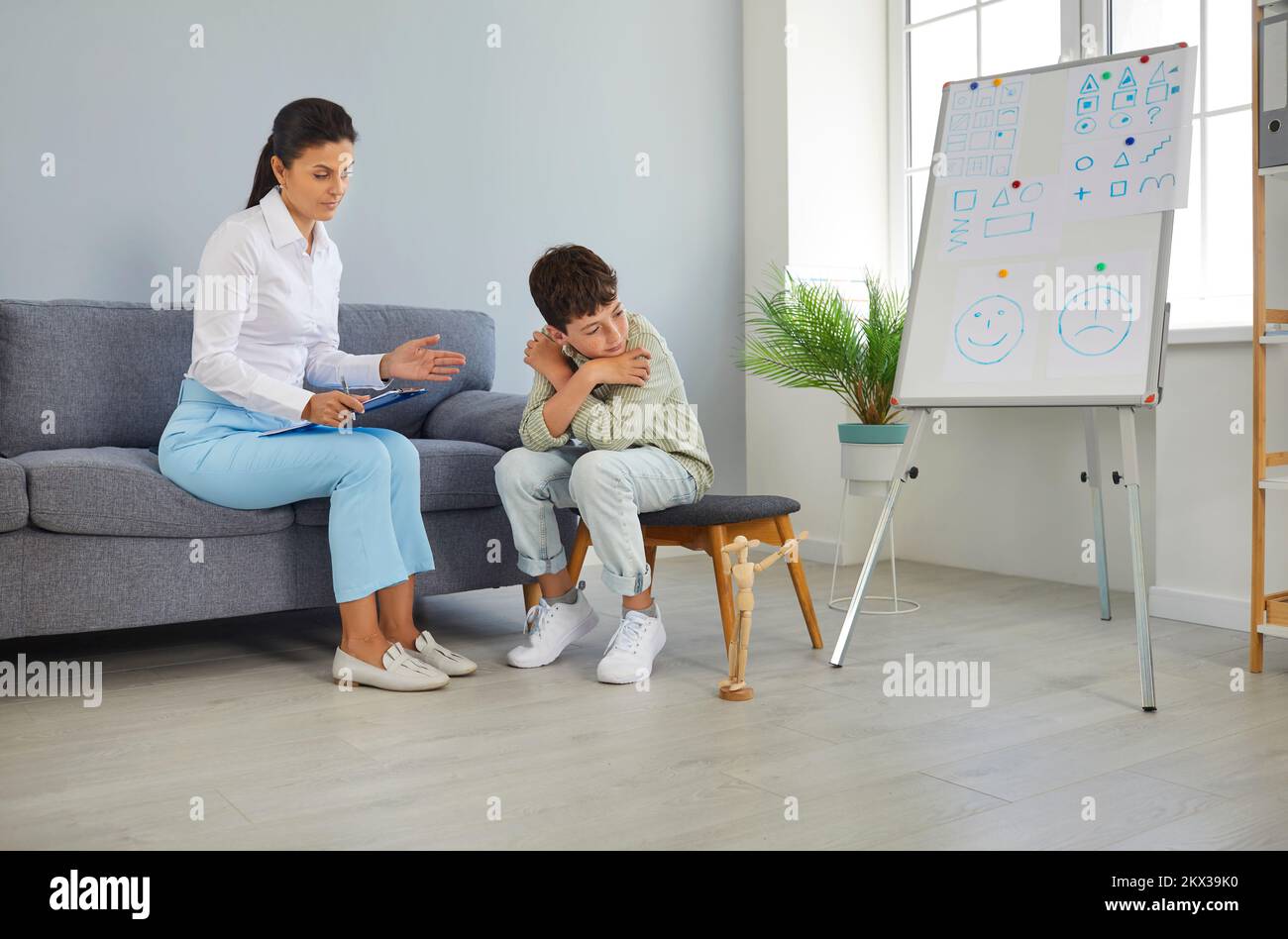 School teacher, counselor or psychologist communicating with sad, depressed child Stock Photo