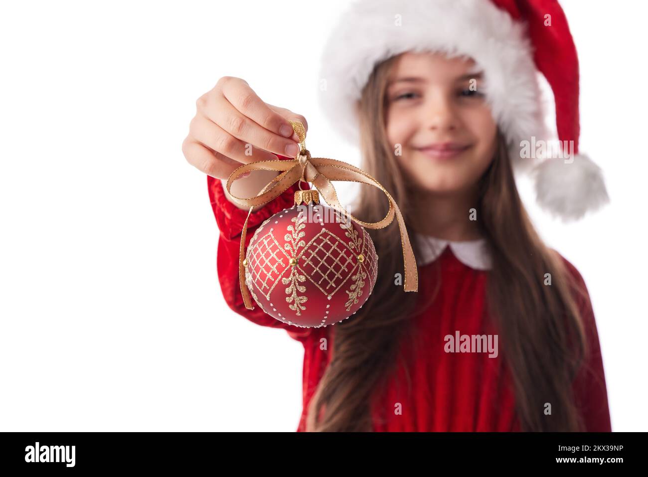 Smiling woman with Christmas tree shining ball, girl posing in red dress of Santa Claus on white background Stock Photo