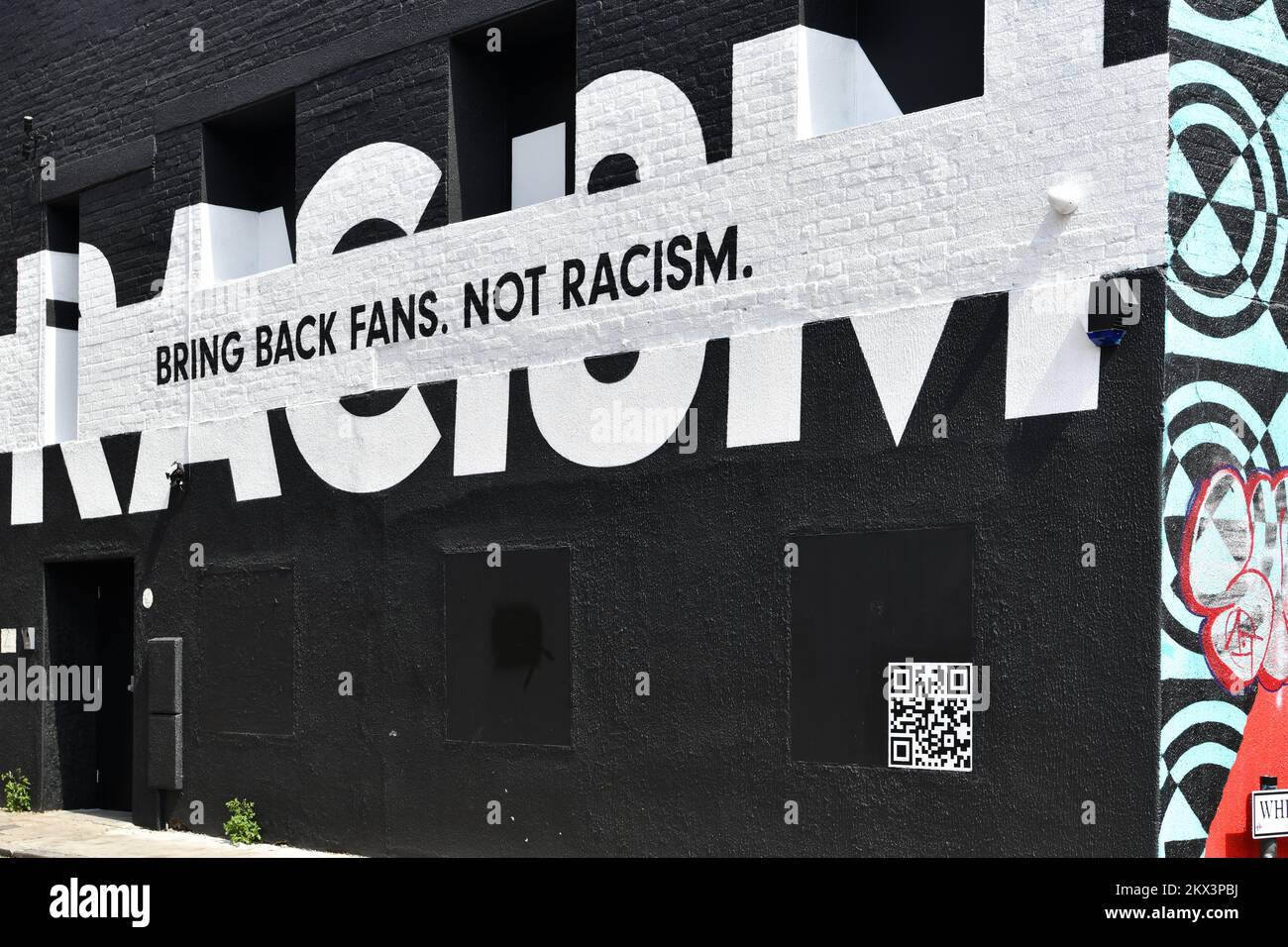 Bring back fans not racism black and white painted mural on wall in Shoreditch London Stock Photo