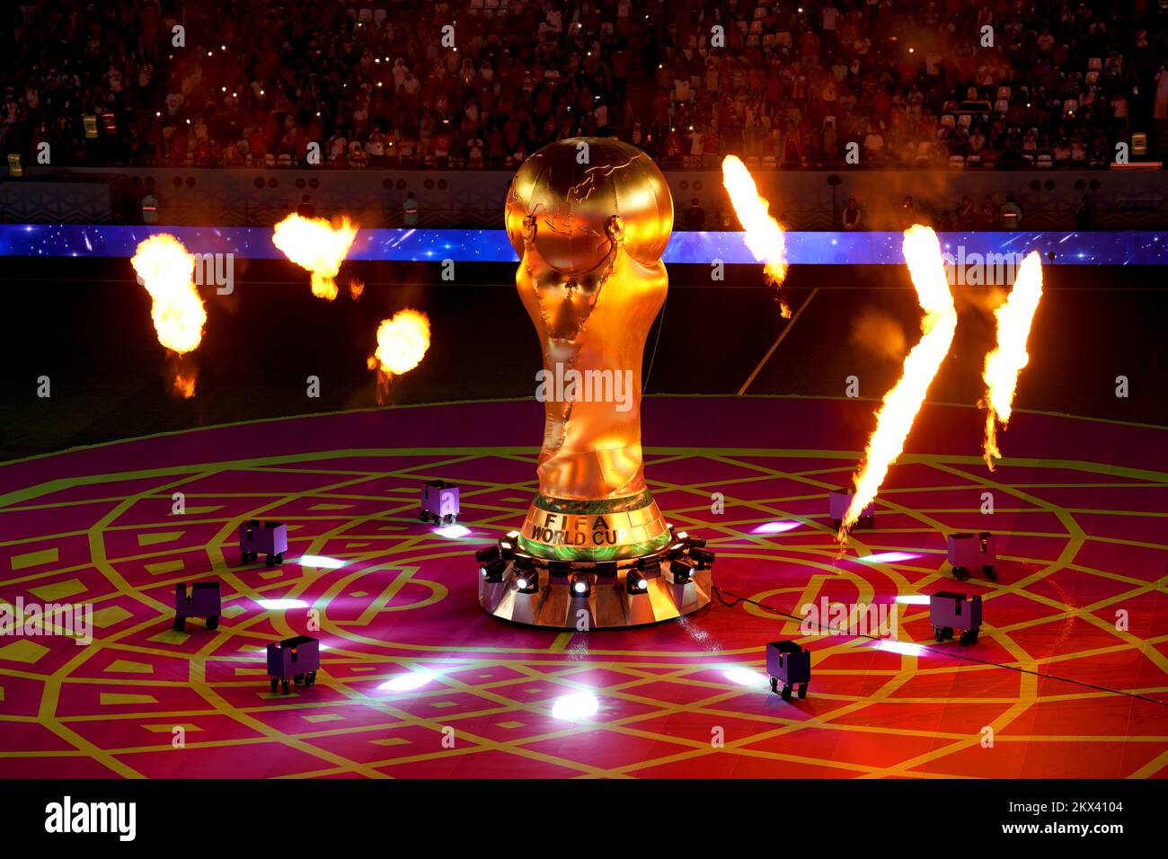 Pyrotechnics go off around a large scale replica of the FIFA World Cup Trophy ahead of the FIFA World Cup Group D match at the Education City Stadium in Al Rayyan, Qatar. Picture date: Wednesday November 30, 2022. Stock Photo