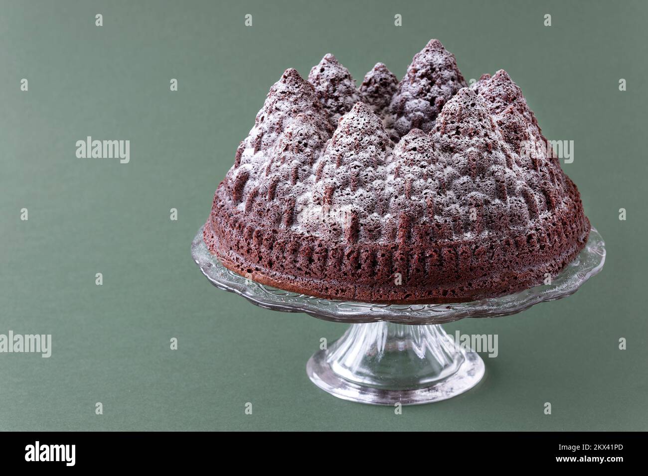 A festive christmas chocolate cake. The cake is made using a Bundt tin to form the cake batter into the tree shapes. A sprinkle of icing sugar tops it. Stock Photo